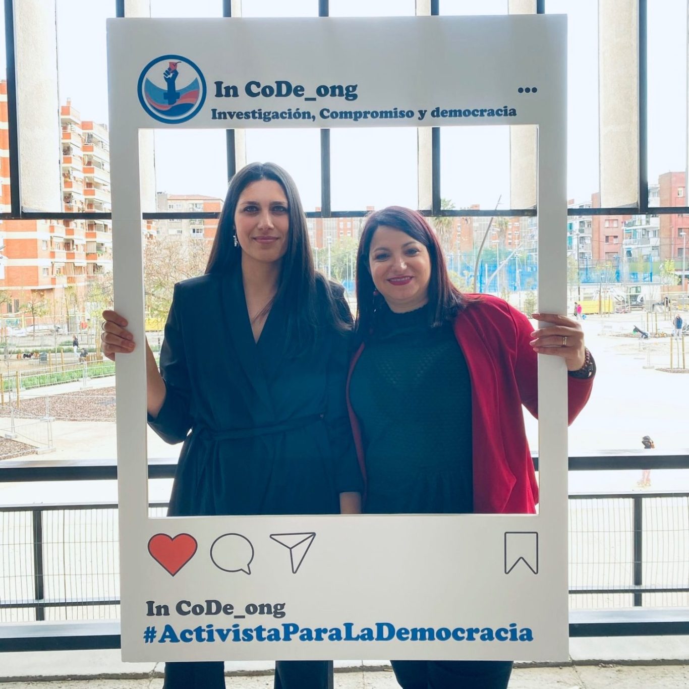Activistas de In CoDe por la democracia digital y feminista Dos activistas feministas de In CoDe con una cornisa de Instagram que muestra el lema “Activista para la democracia”.